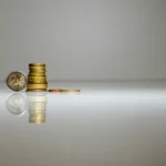 a stack of coins sitting on top of a reflective surface