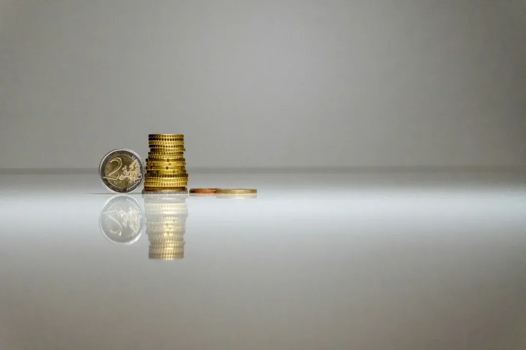 a stack of coins sitting on top of a reflective surface
